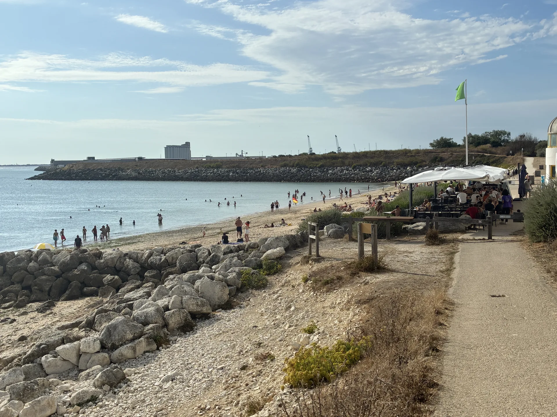 Plage et terrasse allée Michèle-Jaehrling à Technocean, Chef de Baie, La Rochelle, avec les silos et grues du port de commerce en arrière-plan